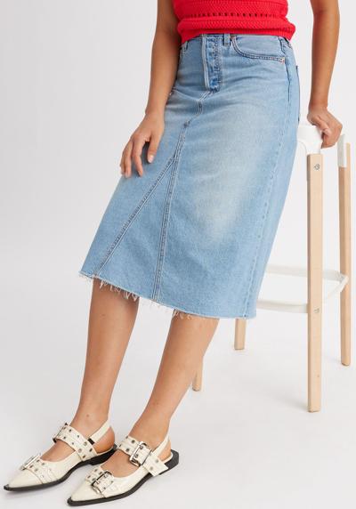 Джинсовая юбка модной длины миди с потертыми краями.