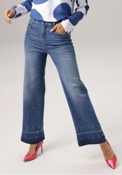 Прямые джинсы с модной потертостью на слегка потрепанном подоле.