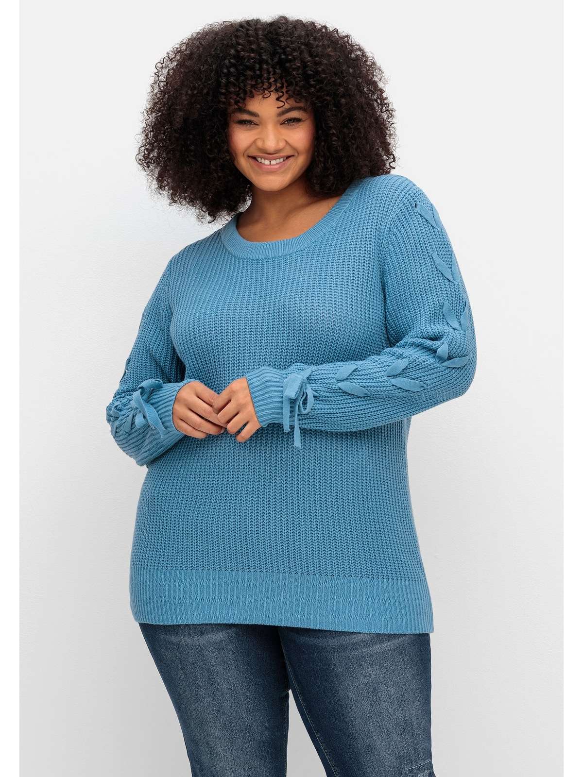 Вязаный свитер с плетеными лентами на рукавах.