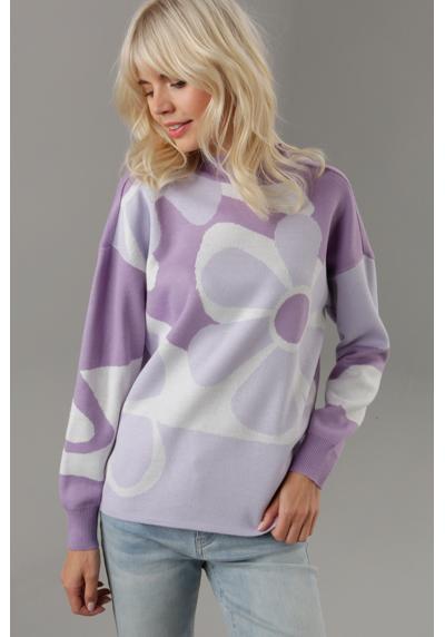 Вязаный свитер с крупным цветочным узором.