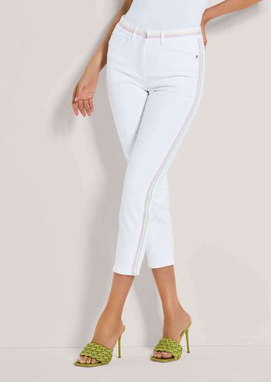 Узкие джинсы 7/8 с яркими полосатыми акцентами.