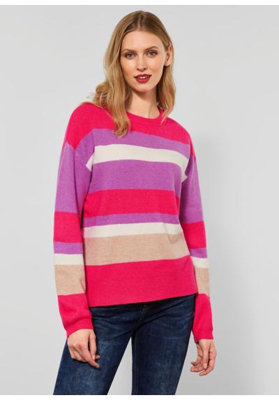 Вязаный свитер с ярким полосатым узором.