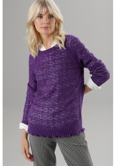 Вязаный свитер ажурным узором и волнистым краем.