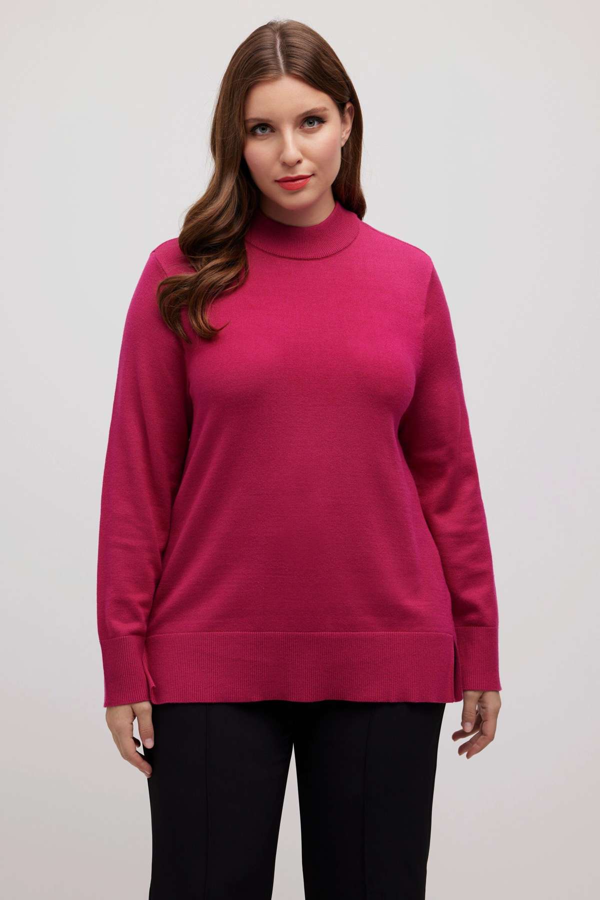 Вязаный пуловер с воротником стойкой и длинными рукавами мягкой тонкой вязки.